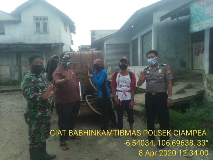 Cegah Corona, Bhabinkamtibmas Polsek Ciampea Semprot Disinfektan di Desa Binaan
