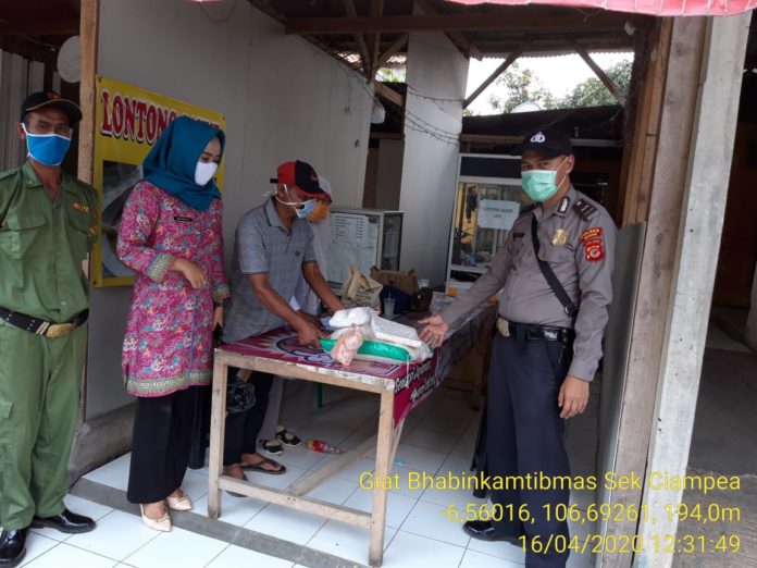 Dampingi Warga, Bhabinkamtibmas Polsek Ciampea Polres Bogor Hadiri Pembagian BPNT.