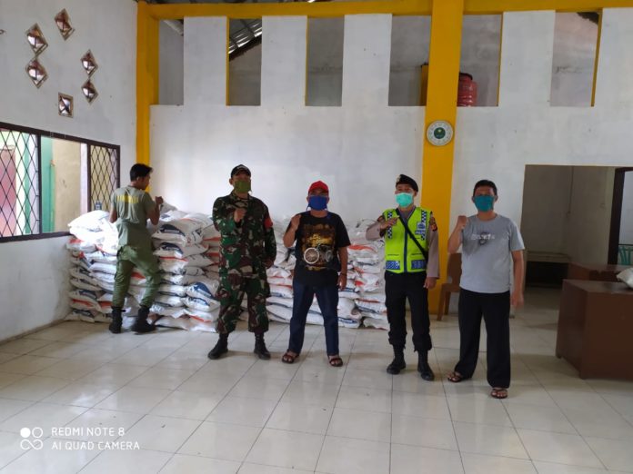 Bhabinkamtibmas Polsek Ciampea Bersama Babinsa Monitoring Distribusi Bantuan Beras untuk Warga Yang Terkena Dampak Covid-19 Dari Bupati Bogor.