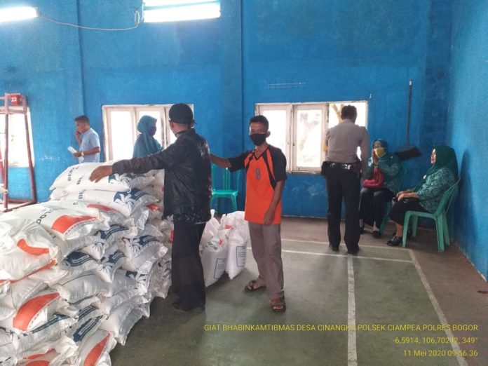 Bhabinkamtibmas Polsek Ciampea Kawal Distribusi Bantuan Pemkab Bogor untuk Masyarakat Kurang Mampu Paskah Corona Covid-19