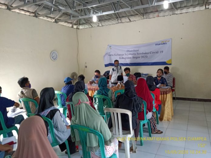 Bhabinkamtibmas Polsek Ciampea Bersama Babinsa Laksanakan Pengamanan Pembagian Kartu Kesejahteraan Sosial (KKS)