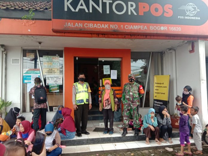 Bhabinkamtibmas Polsek Ciampea Amankan Penyaluran BST Tahap Ke 3 di Kantor Pos Ciampea.